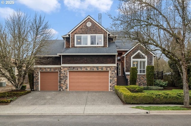 view of front of property featuring fence, concrete driveway, roof with shingles, central AC unit, and an attached garage