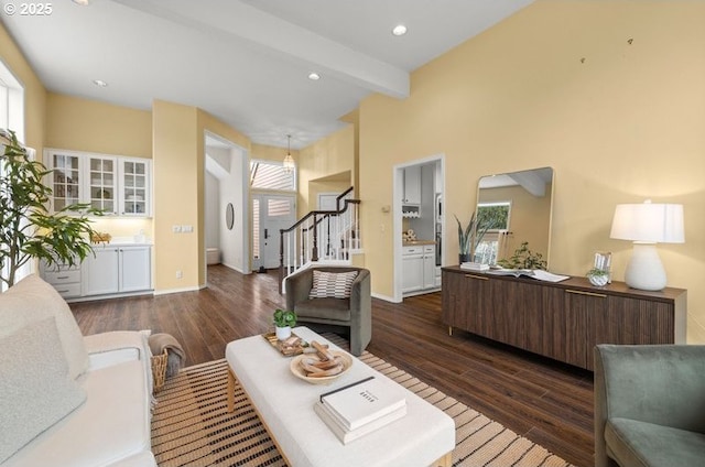 living room featuring beam ceiling, recessed lighting, stairway, baseboards, and dark wood-style flooring