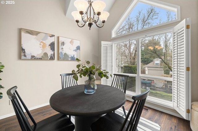 dining room featuring dark wood-style floors, baseboards, a towering ceiling, and a chandelier