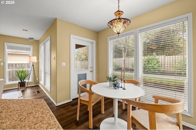 dining area with an inviting chandelier, dark wood-style floors, baseboards, and visible vents