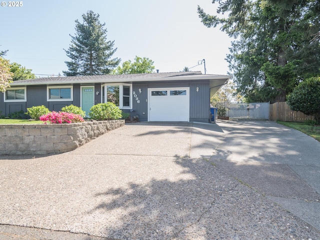 view of front of house with driveway, an attached garage, and fence