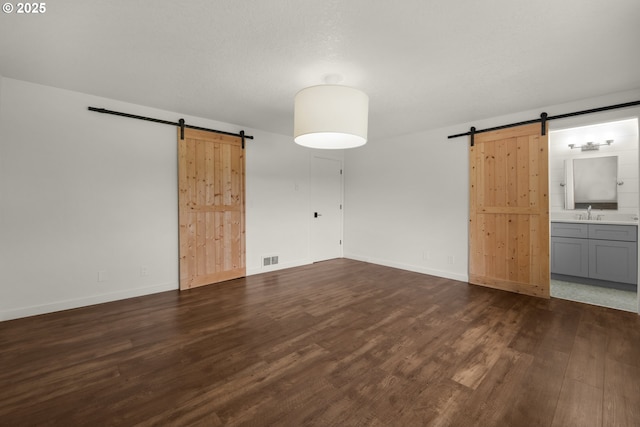 657 Summit Ave, Gearhart, OR 97138 - spare room with a barn door and dark wood-style flooring