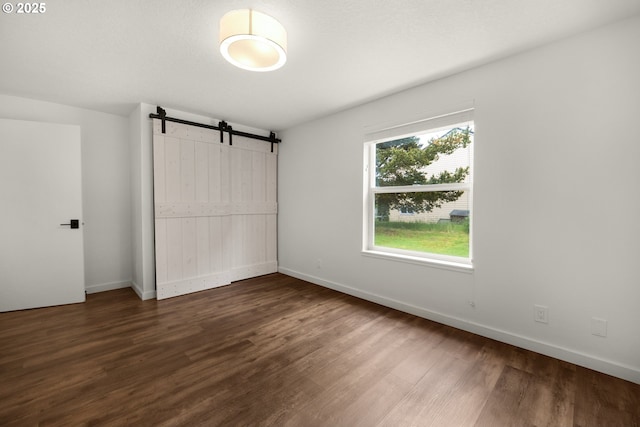 657 Summit Ave, Gearhart, OR 97138 - unfurnished bedroom featuring wood finished floors, a barn door, and a closet