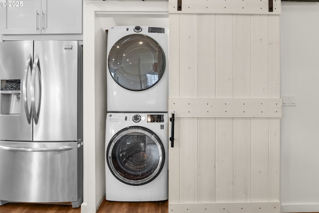 657 Summit Ave, Gearhart, OR 97138 - laundry area with stacked washer / dryer, wood finished floors, and a barn door