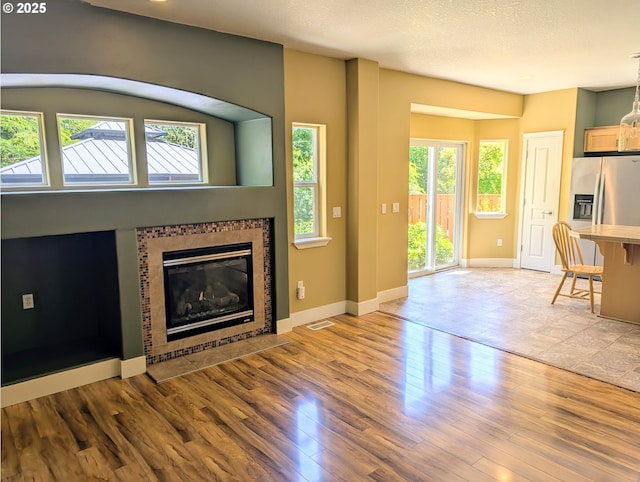 17458 SW Inkster Dr, Sherwood, OR 97140 - unfurnished living room featuring healthy amount of natural light, a tiled fireplace, and wood finished floors