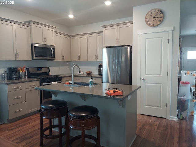 16610 Pine Creek Dr, La Pine, OR 97739 - kitchen featuring appliances with stainless steel finishes, dark wood-style flooring, a kitchen breakfast bar, gray cabinets, and recessed lighting