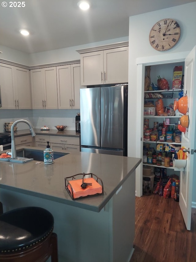 16610 Pine Creek Dr, La Pine, OR 97739 - kitchen with freestanding refrigerator, a breakfast bar, dark wood-type flooring, dark countertops, and recessed lighting