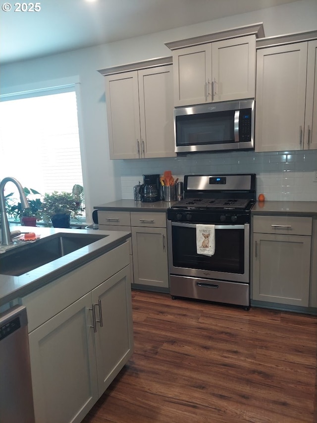 16610 Pine Creek Dr, La Pine, OR 97739 - kitchen featuring appliances with stainless steel finishes, decorative backsplash, dark wood-type flooring, and gray cabinetry