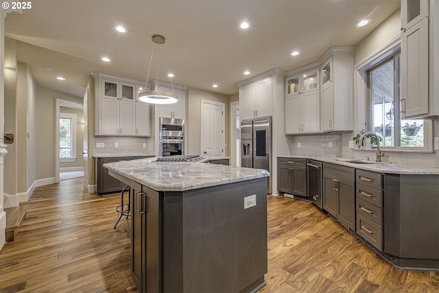 21540 SW 110th Pl, Tualatin, OR 97062 - kitchen featuring a sink, appliances with stainless steel finishes, a center island, wood finished floors, and recessed lighting