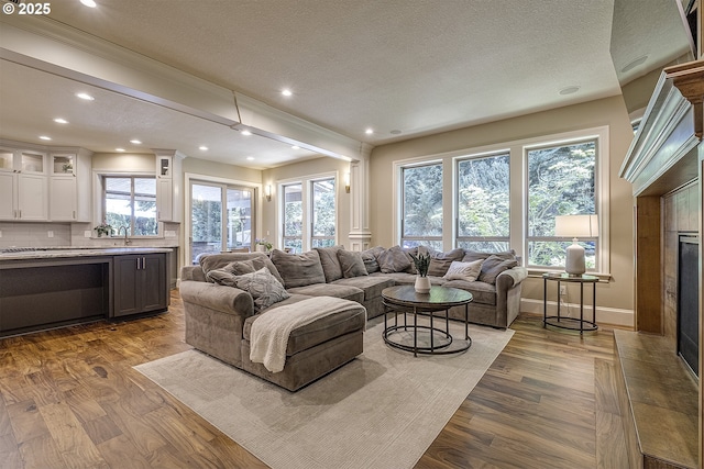 21540 SW 110th Pl, Tualatin, OR 97062 - living room with a textured ceiling, wood finished floors, recessed lighting, a tiled fireplace, and ornamental molding