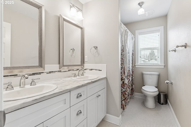 bathroom featuring vanity, toilet, tile patterned flooring, and backsplash