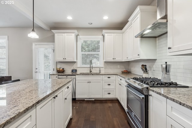 kitchen featuring wall chimney exhaust hood, sink, light stone counters, appliances with stainless steel finishes, and white cabinets