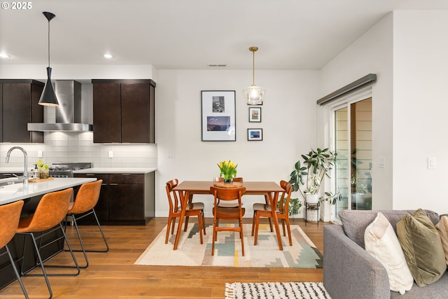 dining space with sink and light wood-type flooring