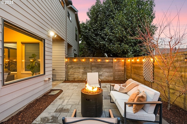 patio terrace at dusk with an outdoor living space with a fire pit