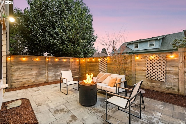 patio terrace at dusk featuring an outdoor living space with a fire pit