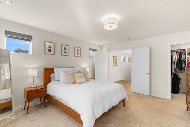 carpeted bedroom with a closet and a walk in closet