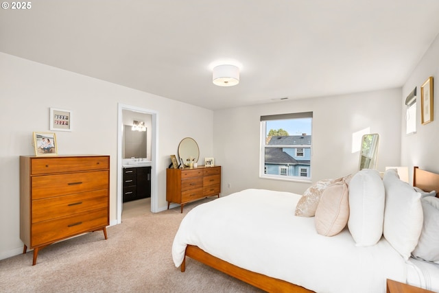 bedroom featuring connected bathroom and light colored carpet