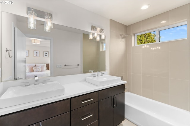 bathroom featuring vanity and tiled shower / bath