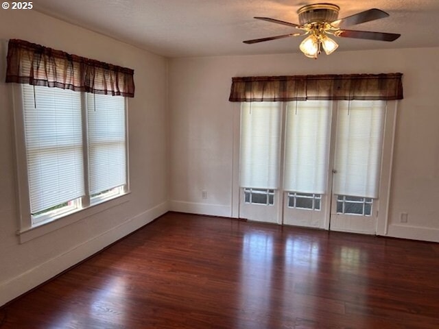 unfurnished room with ceiling fan, a textured ceiling, baseboards, and wood finished floors