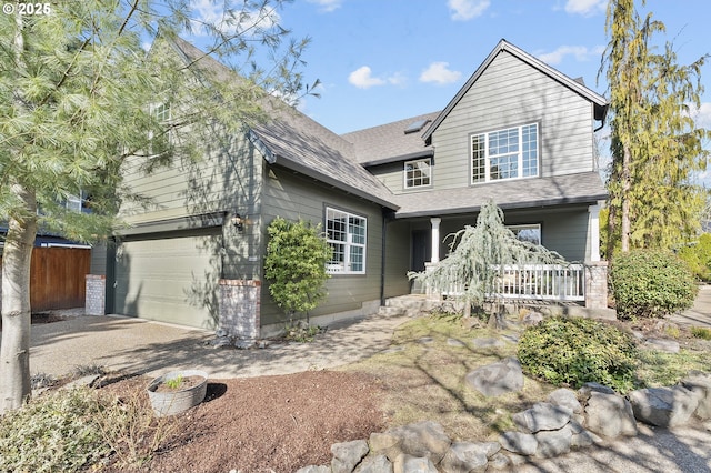 traditional home featuring a garage, a shingled roof, and a porch