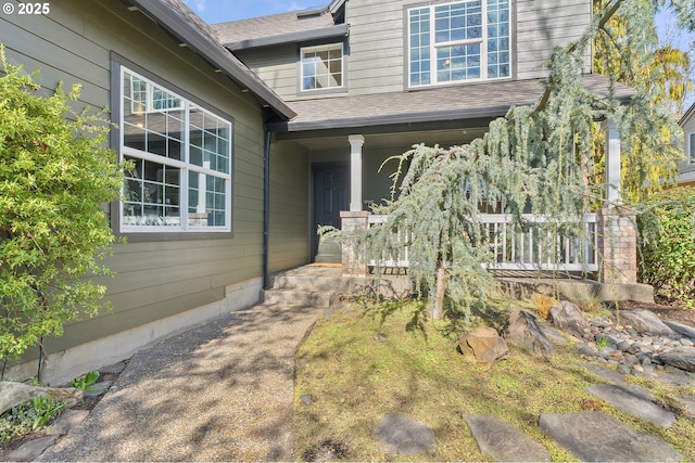 property entrance with a porch and a shingled roof