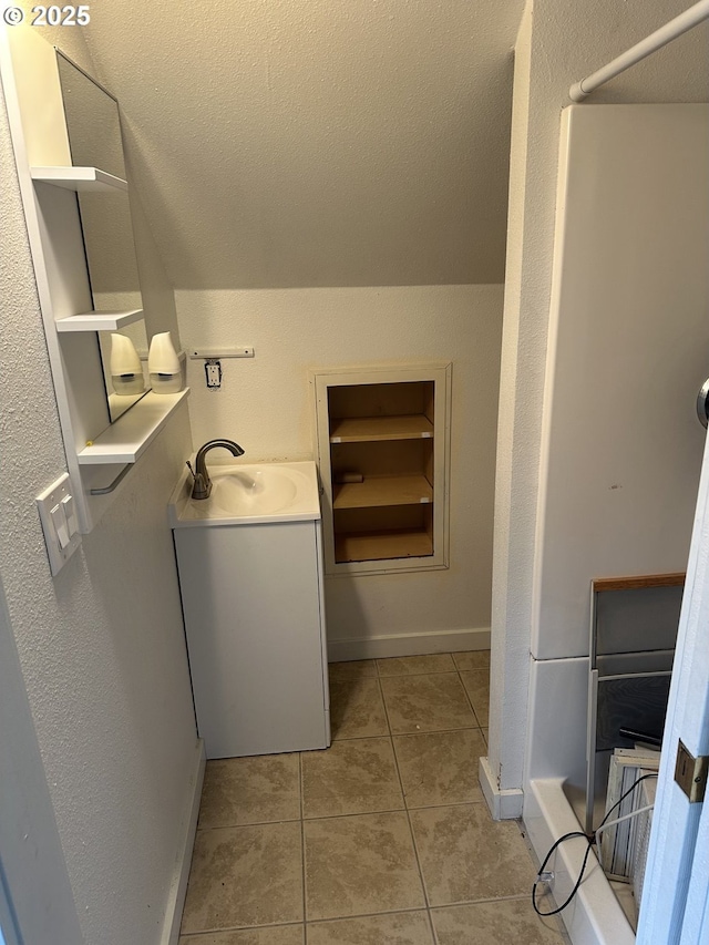 bathroom with tile patterned flooring, a textured ceiling, vanity, and baseboards