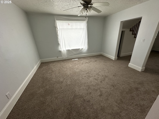 unfurnished bedroom featuring a ceiling fan, carpet, baseboards, and a textured ceiling