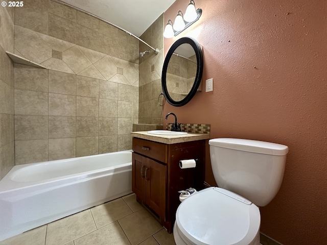 full bathroom with tiled shower / bath, tile patterned floors, toilet, and vanity