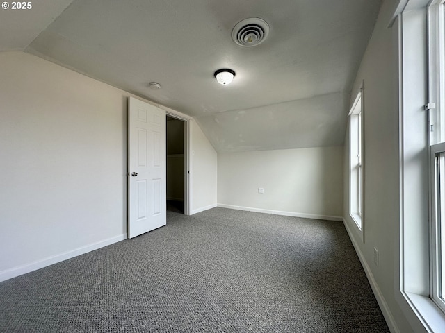 bonus room featuring lofted ceiling and dark carpet