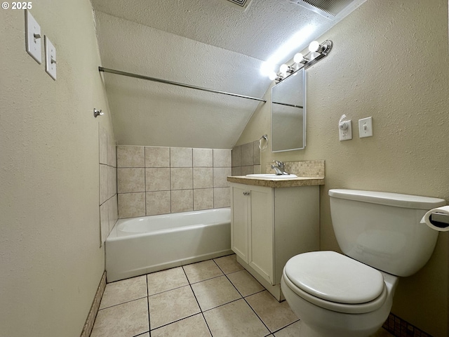 bathroom featuring tile patterned flooring, vanity, a textured ceiling, a tub, and toilet