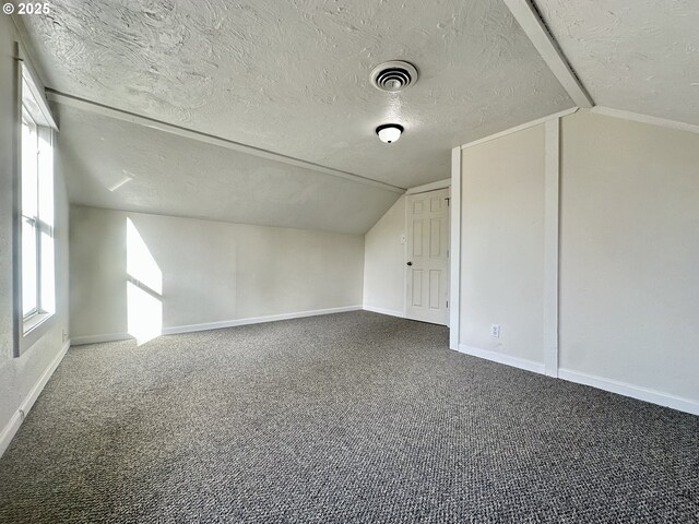 bonus room featuring lofted ceiling, carpet floors, and a textured ceiling