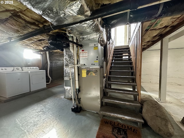 basement featuring washing machine and clothes dryer and heating unit