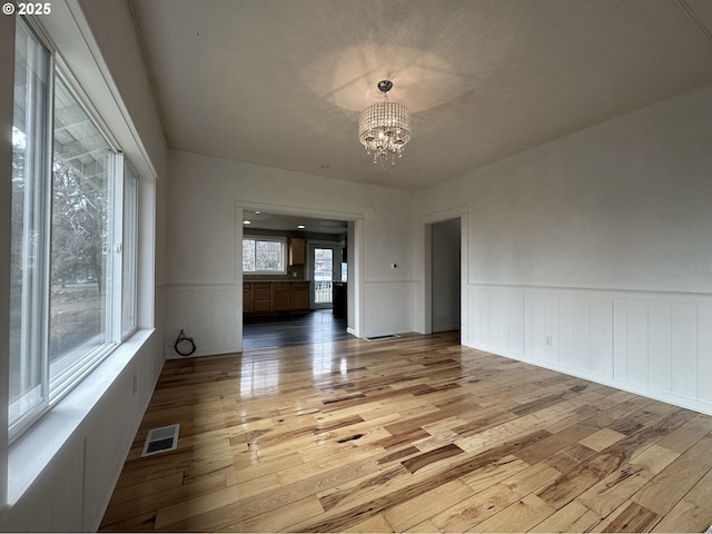 unfurnished room featuring light hardwood / wood-style floors and a chandelier