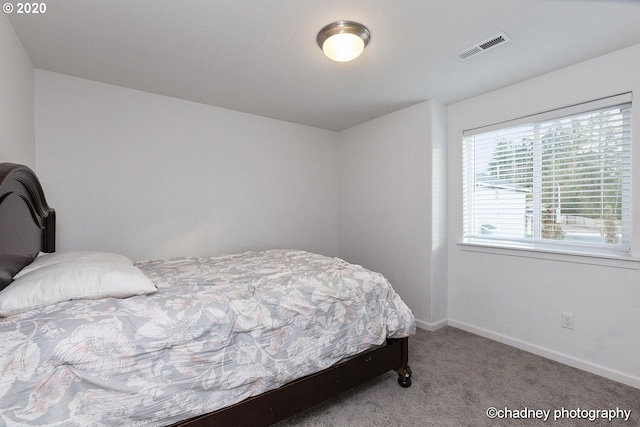 carpeted bedroom with visible vents and baseboards