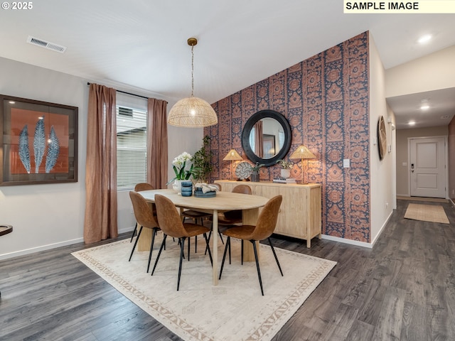 kitchen featuring white cabinetry, light countertops, a breakfast bar area, stainless steel appliances, and dark wood finished floors