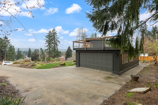 garage featuring fence and driveway