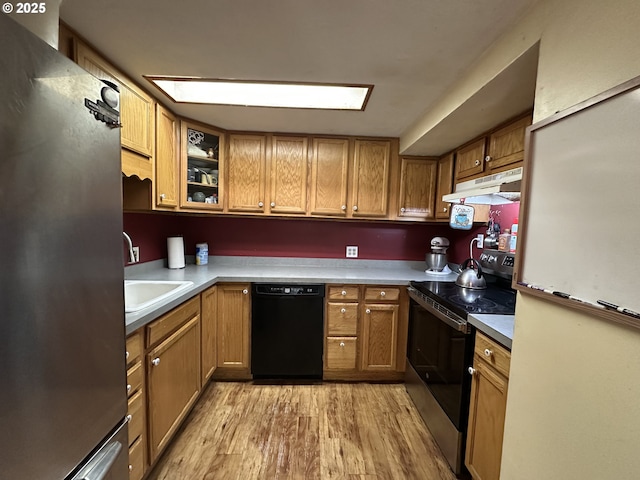 440 N Mountain Blvd, Mount Vernon, OR 97865 - kitchen with stainless steel appliances, under cabinet range hood, light wood finished floors, a sink, and brown cabinets