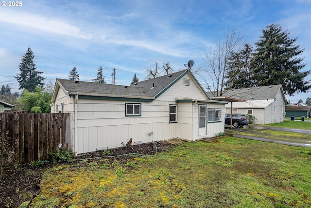 rear view of property with a yard and fence