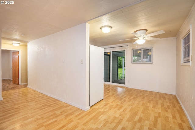 spare room with baseboards, a ceiling fan, and wood finished floors