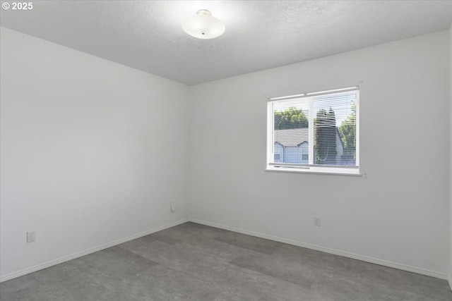 unfurnished room featuring a textured ceiling and baseboards