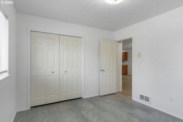 unfurnished bedroom featuring baseboards, a closet, and multiple windows