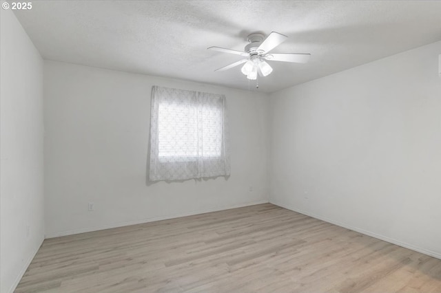 unfurnished room featuring light wood-style flooring, ceiling fan, baseboards, and a textured ceiling