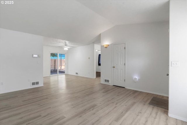 spare room with light wood-style floors, a ceiling fan, vaulted ceiling, and baseboards