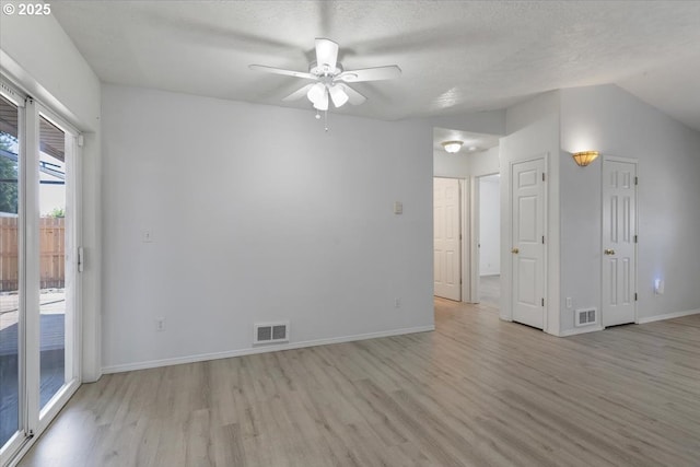 spare room with light wood-style floors, a ceiling fan, baseboards, and a textured ceiling