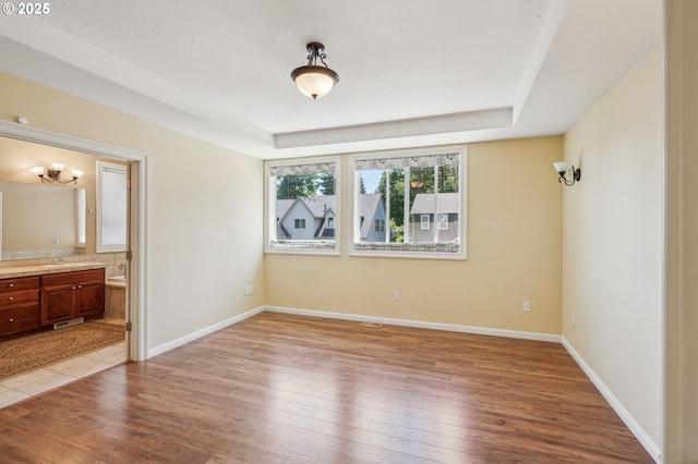 1145 NW 22nd Ave, Camas, WA 98607 - unfurnished bedroom with a raised ceiling, wood finished floors, a sink, and baseboards