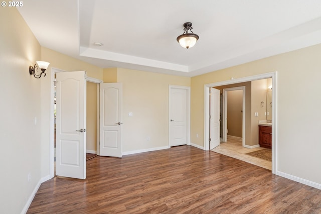 1145 NW 22nd Ave, Camas, WA 98607 - unfurnished bedroom with wood finished floors, a tray ceiling, and baseboards