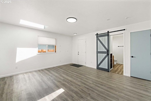 3060 Pine St, North Bend, OR 97459 - empty room with a barn door, wood finished floors, and baseboards
