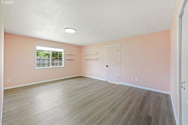 3060 Pine St, North Bend, OR 97459 - empty room with wood finished floors, baseboards, and a textured ceiling