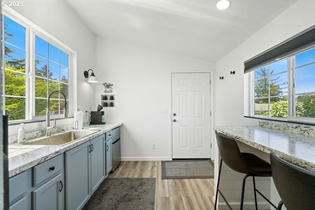 3060 Pine St, North Bend, OR 97459 - kitchen featuring a sink, vaulted ceiling, light wood-style flooring, healthy amount of natural light, and light stone counters