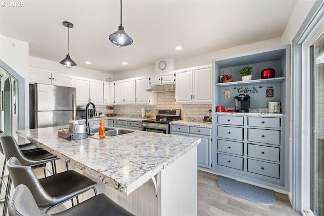 3060 Pine St, North Bend, OR 97459 - kitchen with stainless steel appliances, under cabinet range hood, light wood-style flooring, white cabinetry, and recessed lighting